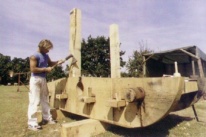 The base of a medieval onager being shaped with an axe.