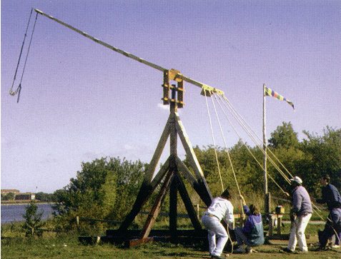 A crew haul on rope to shoot a traction trebuchet